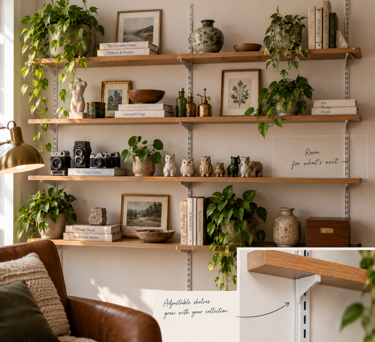 Modern adjustable track shelving with oak shelves and wall-matched metal rails, displaying ceramics, books, framed art, and collectibles with one open section left for future additions.