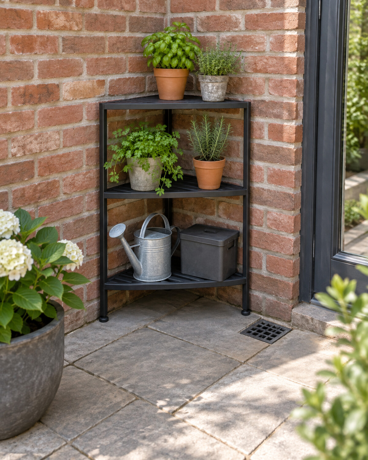Triangular corner shelf holding small pots and garden accessories on a compact patio